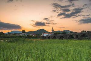 puesta de sol a el medieval puente a ponte Delaware lima, Portugal. foto