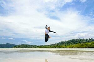 Happy asian woman jumping fun on the beach photo