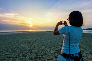 Woman tourist taking photo on the beach