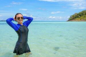 asiático adolescente niña es relajarse en el mar durante viaje a ko labio, Tailandia foto