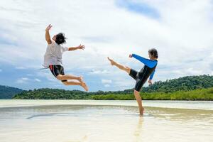 Couple play fun woman show kicking a man on the beach photo