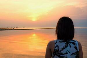 Woman watching Sunset at the beach photo