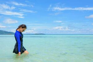 asiático mujer caminando en el mar a viaje a koh lipe isla foto