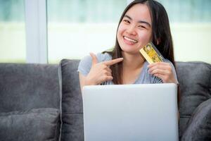 Girl smile pointing finger at credit card photo
