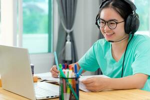asiático mujer estudiante contento en clase en línea aprendizaje foto