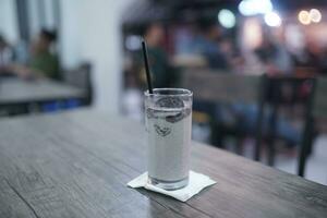 Chocolate milkshake with chocolate pieces and cake on top, cafe background atmosphere photo