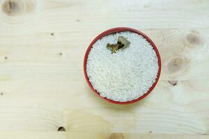 Healthy food. red ceramic bowl with high carb rice on wooden background. Top view, high resolution product. photo