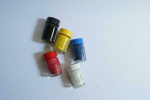 A bunch of neatly arranged watercolors with 5 colors on a white background, powder coloring, cute glass bottles photo