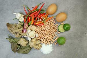 a collection of spices, chilies, onions, nuts and various kinds on a concrete background photo