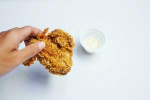 Crispy fried chicken with hands and carbonara sauce on white background photo
