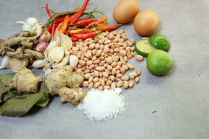 a collection of spices, chilies, onions, nuts and various kinds on a concrete background photo