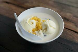 Vanilla ice cream in a bowl on a wooden table photo