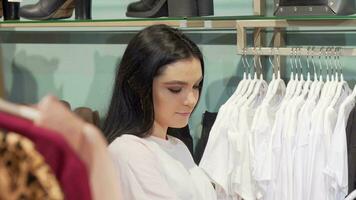 aantrekkelijk jong vrouw genieten van boodschappen doen voor nieuw kleren video