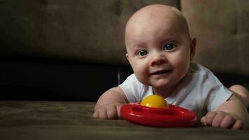 4 month old infant baby lying on sofa with developing toys. video