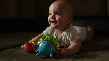 glücklich Säugling Baby Lügen auf Sofa mit Entwicklung Plastik Spielzeug. video