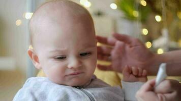 Mother wipes baby mouth with paper napkins after eating. video