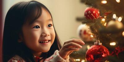 pequeño asiático niña colocación un festivo ornamento en un lozano verde Navidad árbol. ai generativo. foto