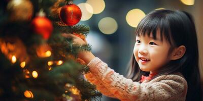 pequeño asiático niña colocación un festivo ornamento en un lozano verde Navidad árbol. ai generativo. foto