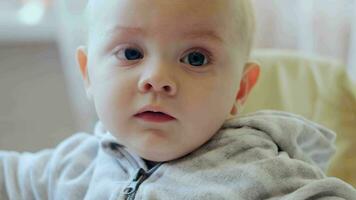 Closeup portrait of 9 month old caucasian infant indoors. video