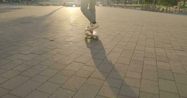 Aziatisch mannetje het schaatsen met verheven armen naar beneden de straat in langzaam beweging gedurende de zonsondergang. vrijheid en dankbaarheid concept. video