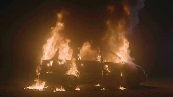 queimando carro lento movimento Largo tomada. automóvel em fogo Preto fundo. carro explosão às noite video