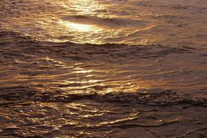 Textures of incoming surf at sunset photo