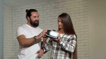 Handsome bearded man watching his girlfriend using virtual reality glasses video