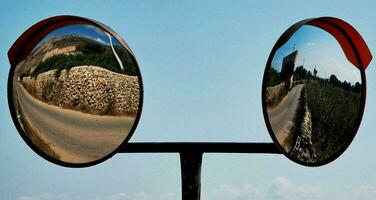 two mirrors reflecting the road in front of them photo