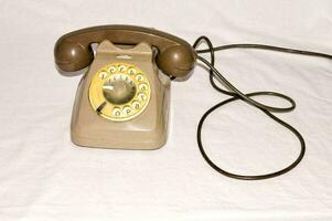 a brown and yellow telephone with a cord photo
