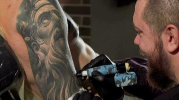 traseiro Visão tiro do uma tatuador fazer tatuagens em a braço do masculino cliente video