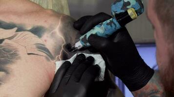 Cropped shot of a professional tattooist working at his studio video