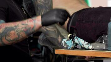 Tattoo artist taking tattoo machine, working at his studio video