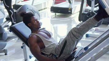 Athletic young African man working out on leg press machine at the gym video