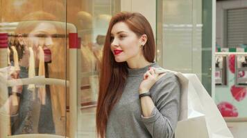 Attractive woman enjoying shopping at the mall, examining clothes on display video