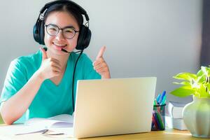 asiático joven mujer estudiante mirando dos pulgares arriba foto