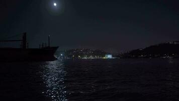 Embarcacion paso mediante el estrecho debajo el luz de la luna. video