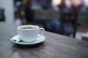 side perspective Coffee in white cup on wooden table in cafe photo