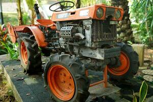 Solo, Indonesia - June 13, 2022 orange rusty tractor engine parts photo