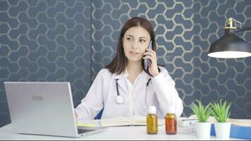 de vrouw dokter is pratend Aan de telefoon. video