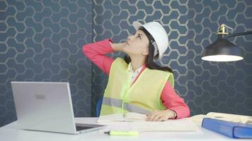 Looking up, the woman engineer is holding her hard hat. video