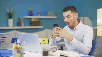 Man working from home enjoys mobile apps on phone. video