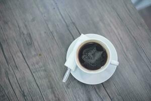 side perspective Coffee in white cup on wooden table in cafe photo