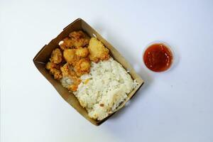 pollo palomitas de maiz y japonés arroz en cartulina caja en blanco antecedentes foto