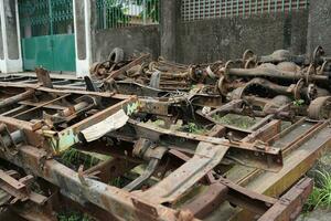 collection of broken metal truck chassis for sale at a junk metal shop photo