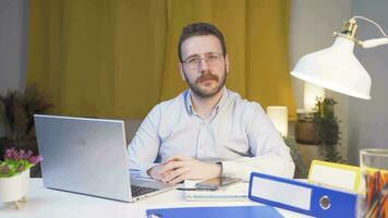 Home office worker man getting good news from camera. video