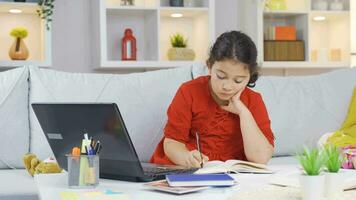 Girl child studying on laptop. video