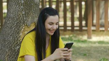 il giovane donna guardare a il Telefono esperienze la gioia. video