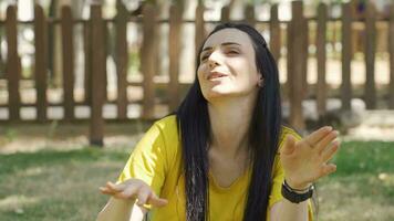 Happy woman sings to herself in the park. video