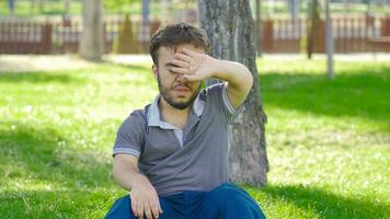 Dwarf young man with fever sitting outdoors. video