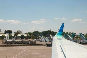 Makassar, Indonesia - September 21th 2023, The atmosphere of the aircraft parking can be seen from the side window of the Garuda Indonesia aircraft wing photo